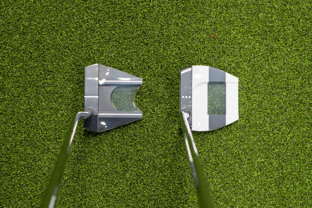 Golf-club-fitting-service-near-me-1030x687 - Tour Quality Golf | Indoor Lessons, Fittings & Virtual Golf Two golf putter heads on a green putting surface, facing each other.